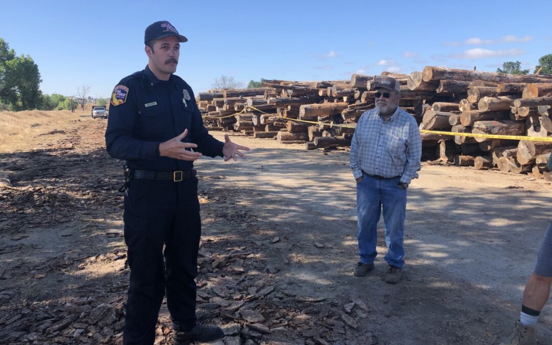 Cal Fire employee with SRCD board member at River Conservancy Location of log decks. Log decks stacked in background.