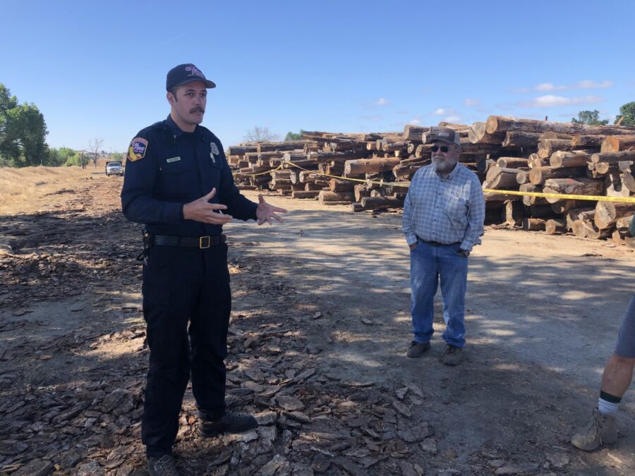 Cal Fire employee with SRCD board member at River Conservancy Location of log decks. Log decks stacked in background.